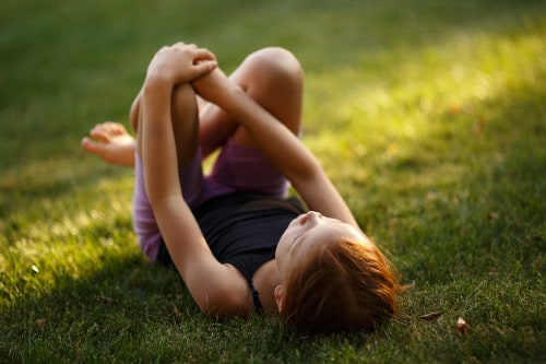 ילדה שוכבת על הדשא